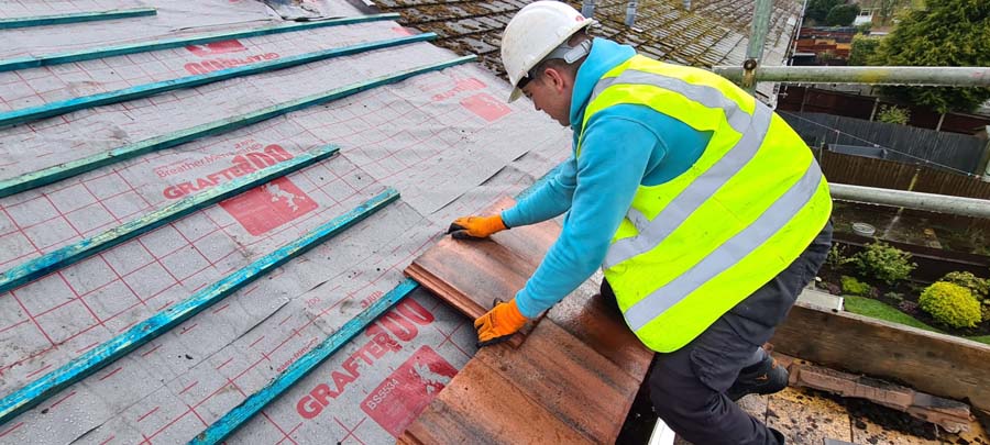 Close up of new roof tiles being applied to roof 3